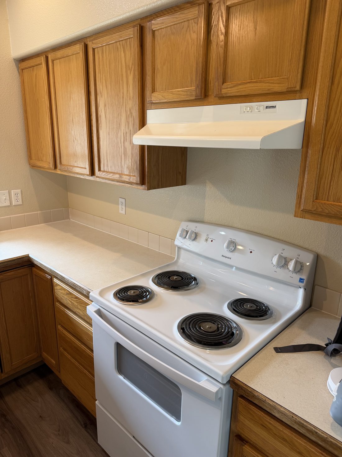 A cleaned kitchen with range, hood and cabinets